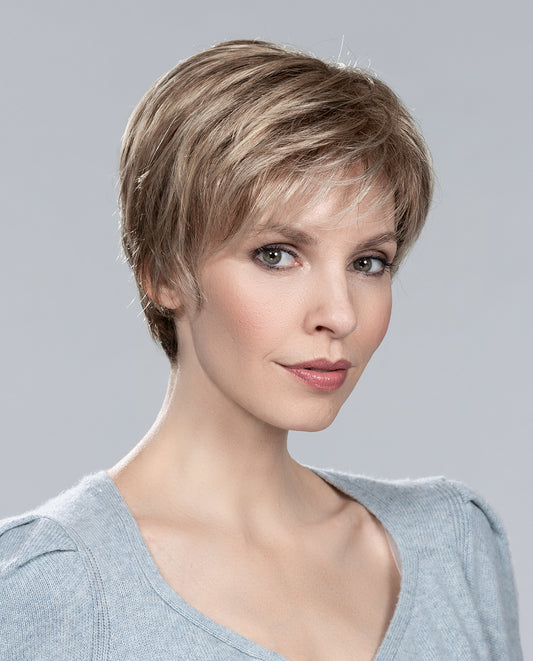 Perruque femme Cara 100 Deluxe, coupe courte et dynamique, idéale pour pelade et alopécie. Style sportif avec touche féminine. Offre vitalité et confort au quotidien pour un look moderne et élégant.