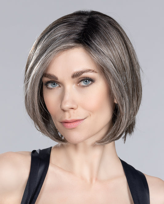 Perruque femme Elite Mono Part, carré classique avec touche moderne. Adaptée aux femmes avec pelade ou alopécie. Tulle cinéma pour ajuster la frange et créer plusieurs styles. Coupe mi-longue et chevelure lisse encadrant le visage, révélant charme et féminité.