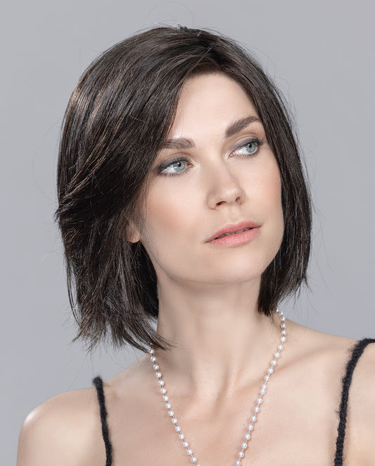 Perruque femme Elite Small Mono Part, carré classique avec touche moderne. Adaptée aux femmes avec pelade ou alopécie. Tulle cinéma pour positionner la frange et créer différents styles. Coupe mi-longue et chevelure lisse encadrant le visage, mettant en valeur charme et féminité.