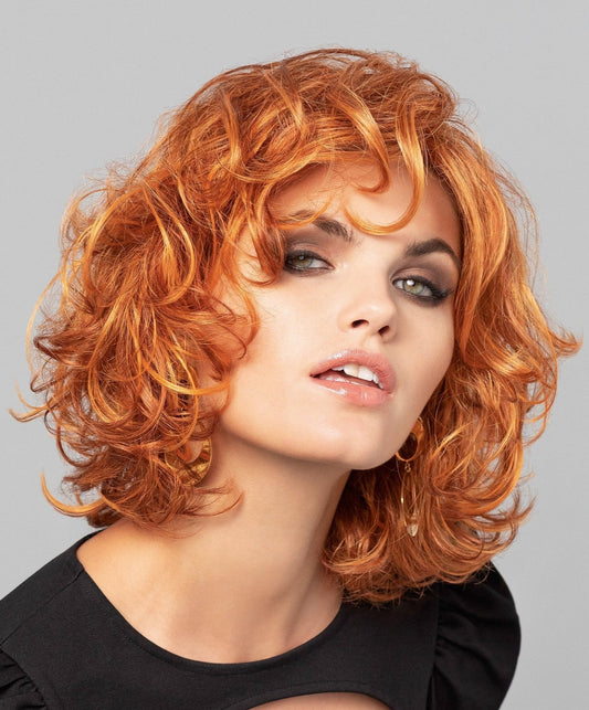 Perruque femme Modern Curl, ondulée et féminine, idéale pour atténuer les effets de la pelade tout en restant élégante.