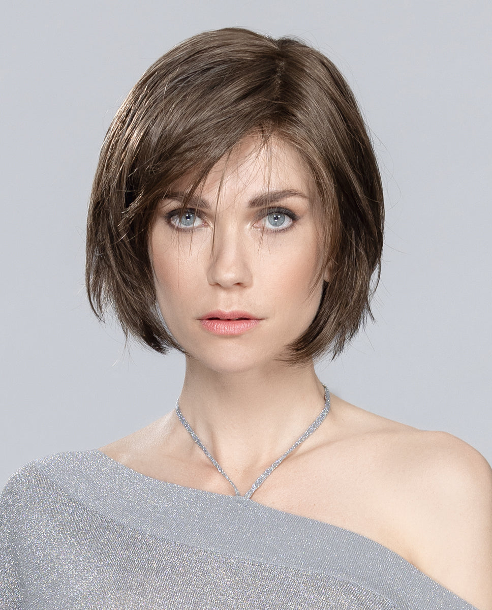Perruque femme Amy Small Deluxe, réinventant le carré court avec des pointes effilées pour un look jeune et dynamique. Sa frange latérale ajoute modernité et style, idéale pour les femmes souffrant de pelade ou d’alopécie. Fabriquée en fibres synthétiques, cette perruque élégante et intemporelle se coiffe facilement pour un look impeccable au quotidien.