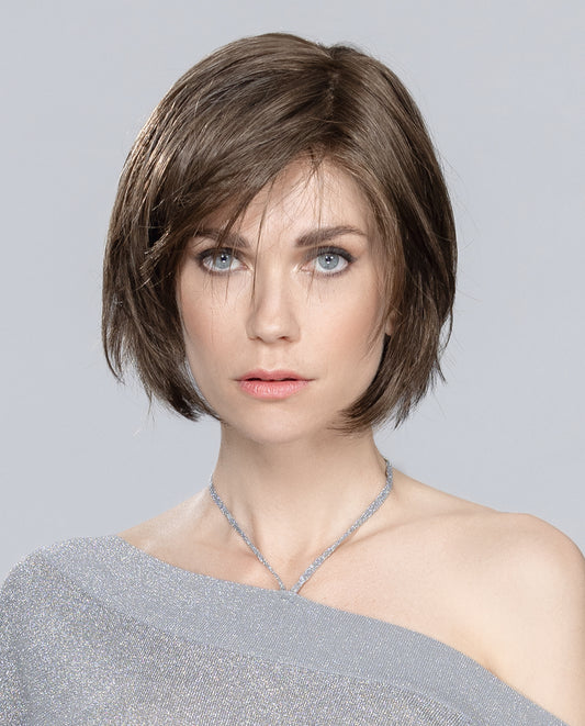Perruque femme Amy Small Deluxe, réinventant le carré court avec des pointes effilées pour un look jeune et dynamique. Sa frange latérale ajoute modernité et style, idéale pour les femmes souffrant de pelade ou d’alopécie. Fabriquée en fibres synthétiques, cette perruque élégante et intemporelle se coiffe facilement pour un look impeccable au quotidien.