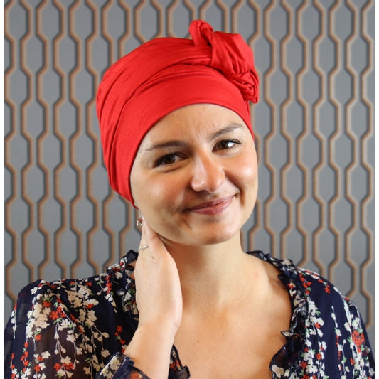 Le bonnet chimio Nola rouge, doux et confortable, s’adapte à toutes vos tenues et apporte une touche féminine avec son nœud élégant.