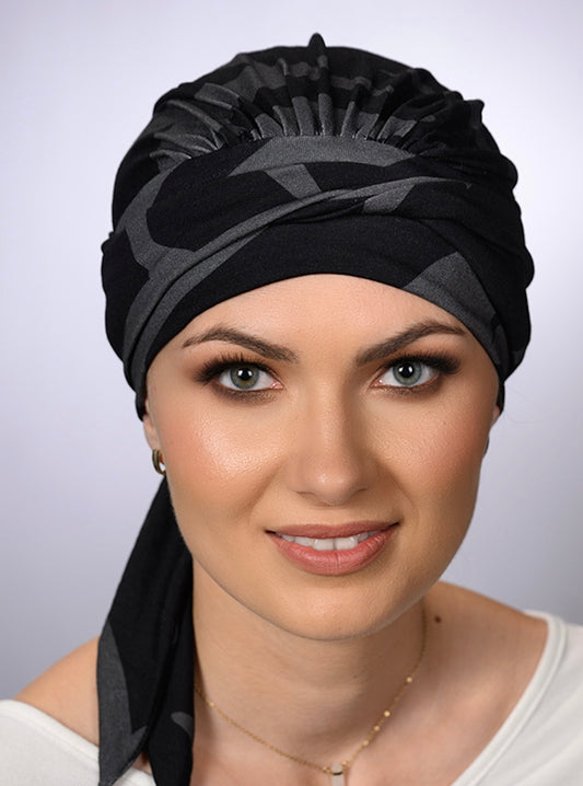 Turban chimio Amy noir à motif raffiné, élégant et confortable, idéal pour alopécie ou chimiothérapie avec style et douceur.
