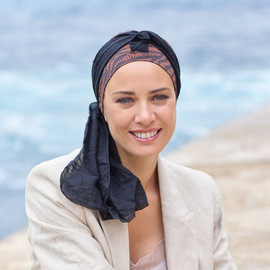 Craquez pour ce Turban chimio souple et ultra confortable, sublimé par un foulard aérien à nouer selon vos envies. Laissez-le flotter librement pour un effet romantique et féminin, ou stylisez-le pour un look plus affirmé.

Parfait mélange de légèreté et d’élégance, ce modèle apporte une touche bohème chic à votre quotidien tout en assurant un maintien doux et agréable. L’accessoire idéal pour composer un style unique, tout en simplicité.